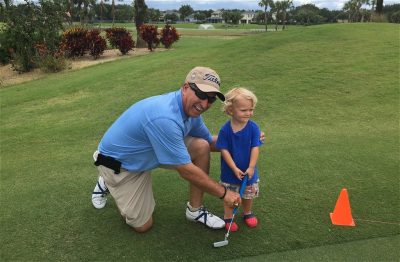 Warren Bottke teaching young child to putt
