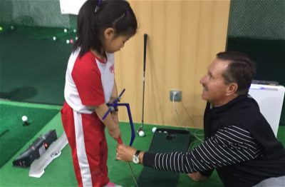 Warren Bottke teaching young child golf